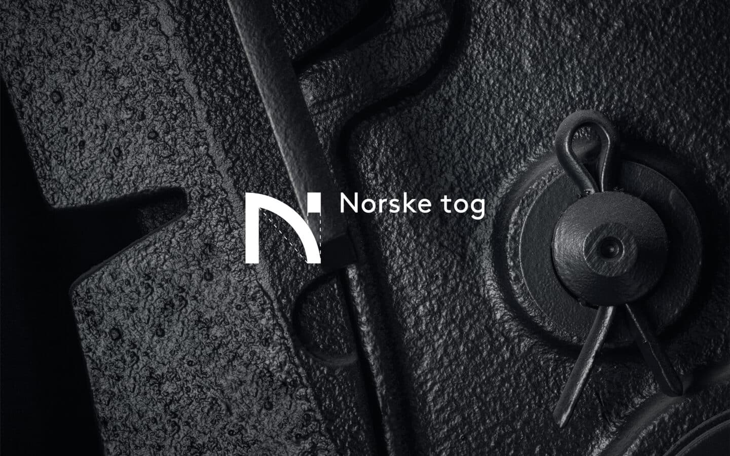Detaljfoto av en del på et tog i svarthvitt, og med Norske tog logo oppå.
