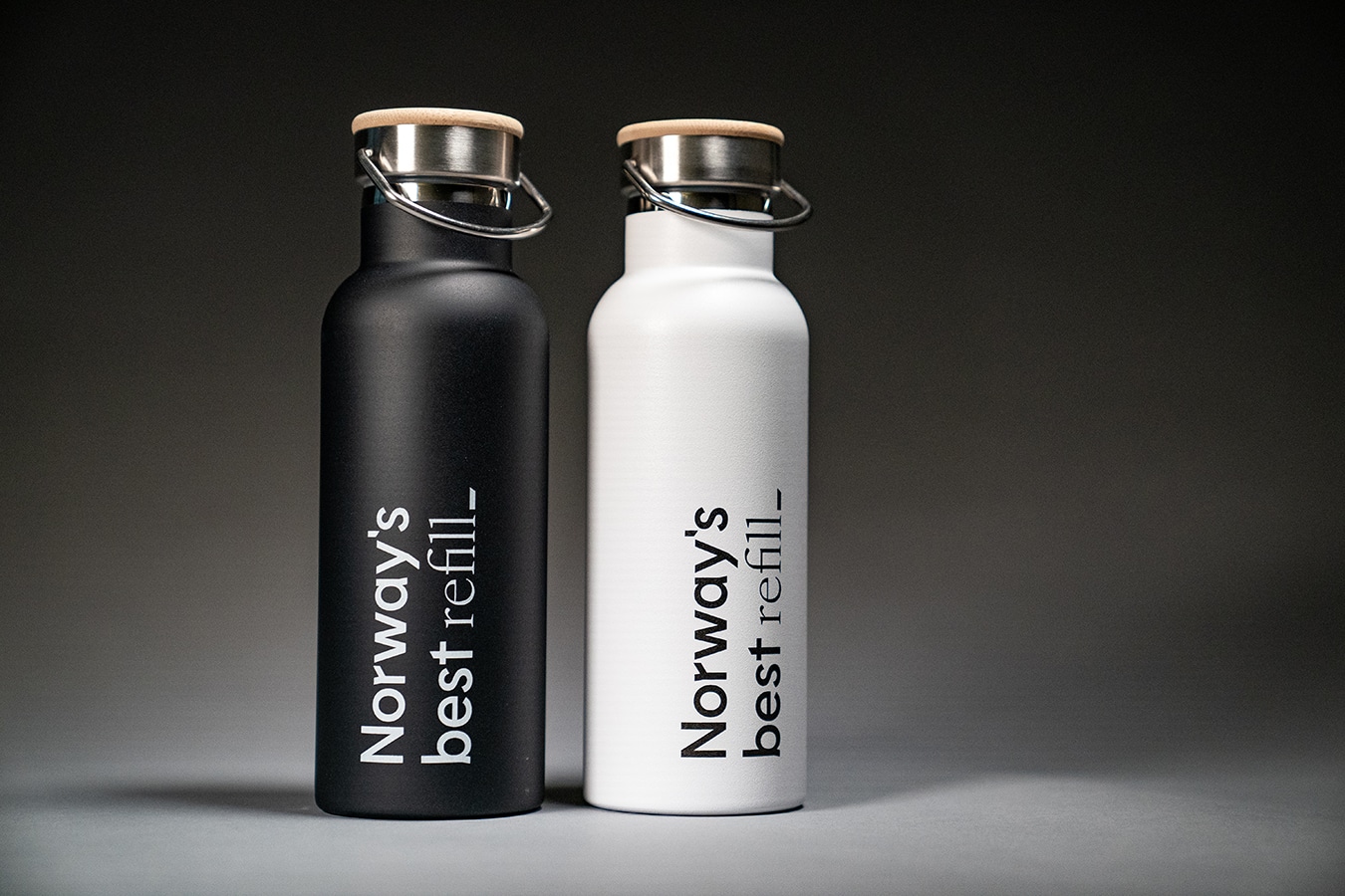 To stykk drikkeflasker, en sort og en hvit. Begge har Norway's best logo, etterfulgt av ordet refill.